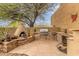 Outdoor kitchen featuring a pizza oven, stone accents, a built-in grill, and a countertop at 10955 E Vista Del Cielo Rd, Gold Canyon, AZ 85118