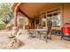 Covered outdoor patio with dining and kitchen area with natural stone accents, a fan, and view to the backyard at 10955 E Vista Del Cielo Rd, Gold Canyon, AZ 85118