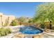 A backyard pool with a rock waterfall feature and desert landscaping with mountain views in the background at 10955 E Vista Del Cielo Rd, Gold Canyon, AZ 85118