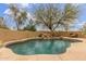 Inviting backyard pool with a rock waterfall feature and desert landscaping surrounded by privacy walls at 10955 E Vista Del Cielo Rd, Gold Canyon, AZ 85118