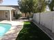 A view of the backyard, showing the green grass, pool, privacy wall, and drought-tolerant landscaping at 1119 E Southshore Dr, Gilbert, AZ 85234