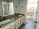 Bathroom vanity featuring dual sinks, granite countertops, and dark fixtures, leading to the shower-tub at 1119 E Southshore Dr, Gilbert, AZ 85234