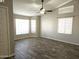 Bright living room featuring wood-look tile flooring, a ceiling fan, and large windows at 1119 E Southshore Dr, Gilbert, AZ 85234