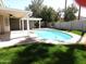 Backyard pool area with grass, a covered patio, and mature trees providing shade at 1119 E Southshore Dr, Gilbert, AZ 85234