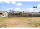 A wide green space behind the property is enhanced by mature trees and a sturdy fence at 11820 S Half Moon Dr, Phoenix, AZ 85044