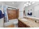 Well-lit bathroom with granite vanity top, a shower-tub combo, and updated fixtures at 11820 S Half Moon Dr, Phoenix, AZ 85044