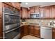 Close-up of the kitchen with stainless steel appliances and dark wood cabinetry at 11820 S Half Moon Dr, Phoenix, AZ 85044