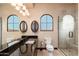 Bathroom features a glass shower, granite countertops and arched window at 12980 E Cochise Rd, Scottsdale, AZ 85259