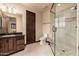 Bathroom features a glass shower, decorative lighting, dark wood cabinets and stone countertops at 12980 E Cochise Rd, Scottsdale, AZ 85259