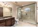 Bathroom features a glass shower, decorative lighting, dark wood cabinets and stone countertops at 12980 E Cochise Rd, Scottsdale, AZ 85259