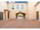 Expansive motor court featuring decorative pavers, arched entryway, and a basketball hoop at 12980 E Cochise Rd, Scottsdale, AZ 85259