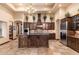 Gourmet kitchen with custom wood cabinetry, a center island, and stainless steel appliances at 12980 E Cochise Rd, Scottsdale, AZ 85259