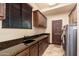 Laundry room features dark wood cabinets, stone countertops, utility sink, and modern washer/dryer at 12980 E Cochise Rd, Scottsdale, AZ 85259