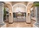 Sophisticated living area with stone columns, a large sofa, and view of the backyard oasis at 12980 E Cochise Rd, Scottsdale, AZ 85259