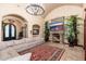 Spacious living room featuring stone fireplace, arched doorways, and a comfortable sectional sofa at 12980 E Cochise Rd, Scottsdale, AZ 85259