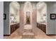 Luxurious bathroom with dual vanities, soaking tub, and travertine details at 12980 E Cochise Rd, Scottsdale, AZ 85259