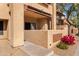 Tan apartment building exterior with a private balcony surrounded by decorative concrete wall and bushes at 1351 N Pleasant Dr # 1045, Chandler, AZ 85225