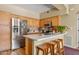 Bright kitchen featuring stainless steel appliances, breakfast bar with wooden stools, and wood cabinetry at 1351 N Pleasant Dr # 1045, Chandler, AZ 85225