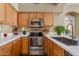 Kitchen with stainless steel range and wooden cabinets in this lovely home at 1351 N Pleasant Dr # 1045, Chandler, AZ 85225