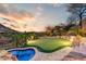 An in-ground pool plus putting green are surrounded by lush desert landscaping in this backyard retreat at 14371 E Kalil Dr, Scottsdale, AZ 85259