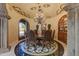 Elegant dining room with a chandelier, custom ceiling details, and a decorative marble floor at 14371 E Kalil Dr, Scottsdale, AZ 85259