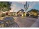 Expansive desert landscaping and large saguaro cacti surrounding this estate at dusk at 14371 E Kalil Dr, Scottsdale, AZ 85259