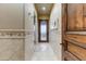 Hallway features travertine floors leading to a glass-enclosed shower and a frosted glass door at 14371 E Kalil Dr, Scottsdale, AZ 85259