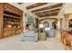 Cozy living room with beamed ceilings, stone fireplace, and an adjacent ornate cabinet at 14371 E Kalil Dr, Scottsdale, AZ 85259