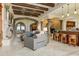 Open-concept living room with marble floors, bar, stone fireplace, and exposed beams creates a grand, inviting space at 14371 E Kalil Dr, Scottsdale, AZ 85259