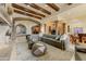 Spacious living room with stone fireplace, exposed beams, and travertine floors at 14371 E Kalil Dr, Scottsdale, AZ 85259