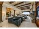 Spacious living room featuring a fireplace, beamed ceilings, an ornate cabinet and an adjacent music room at 14371 E Kalil Dr, Scottsdale, AZ 85259