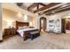 Large main bedroom featuring a decorative bed frame, cozy seating area, and ample natural light at 14371 E Kalil Dr, Scottsdale, AZ 85259