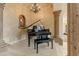 Music room featuring a grand piano, decorative chandelier and adjacent stone column at 14371 E Kalil Dr, Scottsdale, AZ 85259