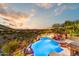 Gorgeous backyard pool with stunning desert and city views at sunset, complete with lounge seating at 14371 E Kalil Dr, Scottsdale, AZ 85259