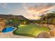 Backyard with putting green and swimming pool overlooking the desert and mountains at 14371 E Kalil Dr, Scottsdale, AZ 85259