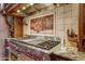 Close up of stainless stovetop with custom tile backsplash and granite countertop at 14371 E Kalil Dr, Scottsdale, AZ 85259