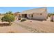 The backyard showcases rock landscaping, mature trees, and a covered patio for outdoor living and relaxation at 14936 W Yosemite Dr, Sun City West, AZ 85375