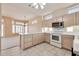 Well-lit kitchen boasts white cabinets, tiled floors, and adjacent dining area with ample windows at 14936 W Yosemite Dr, Sun City West, AZ 85375