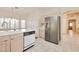 Modern kitchen features stainless steel refrigerator, white cabinetry, and tile flooring at 14936 W Yosemite Dr, Sun City West, AZ 85375