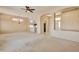 Open-concept living room showcases plush carpet, an archway, and a ceiling fan with light fixture at 14936 W Yosemite Dr, Sun City West, AZ 85375