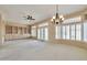 Spacious living room boasts built-in shelves, plush carpet, stylish shutters and elegant chandelier at 14936 W Yosemite Dr, Sun City West, AZ 85375