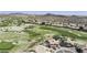 Stunning aerial view of a community featuring a golf course, desert landscape, and beautiful homes with private pools at 16008 S 13Th Way, Phoenix, AZ 85048