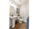 Powder room featuring a pedestal sink, wood-look flooring, and a modern toilet at 16008 S 13Th Way, Phoenix, AZ 85048