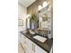 Modern bathroom boasts a dual sink vanity with white cabinets, dark granite counters, and framed mirrors at 16008 S 13Th Way, Phoenix, AZ 85048