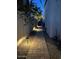 A quaint, private walkway lined with decorative stones and lighting leading to the side yard at 16008 S 13Th Way, Phoenix, AZ 85048