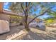 Well-maintained backyard with mature trees, stone patio, and landscaping, perfect for outdoor entertaining and relaxation at 16014 W Kino Dr, Surprise, AZ 85374