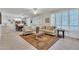 Bright living room featuring tiled floors, plantation shutters, a ceiling fan, and adjacent dining area at 16014 W Kino Dr, Surprise, AZ 85374