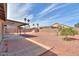 Expansive backyard featuring a covered patio area, a small orange tree, and desert landscaping at 1668 E Valerie St, Casa Grande, AZ 85122