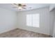 A neutral bedroom is illuminated by a ceiling fan, and the room boasts wood-look floors at 1668 E Valerie St, Casa Grande, AZ 85122