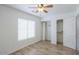 A neutral bedroom is illuminated by a ceiling fan, and has closet with shelving in it at 1668 E Valerie St, Casa Grande, AZ 85122